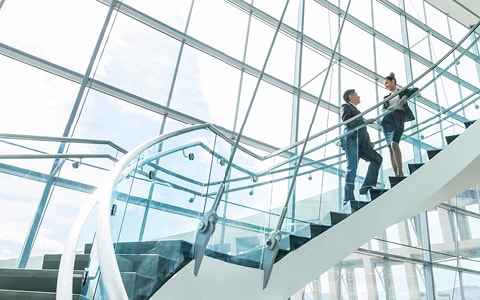 Professionals on steps inside office building 