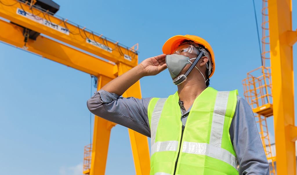 man wearing hard hat and face mark on building site