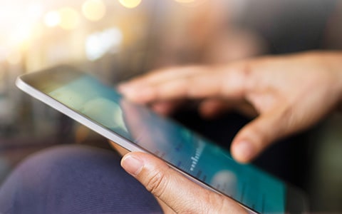 Closeup of hands holding a tablet 