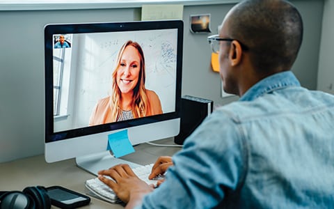 man speaking to colleague over video conference