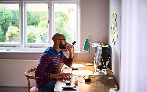 man working from home next to window